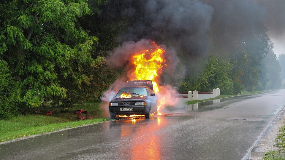горящий автомобиль на обочине дороги