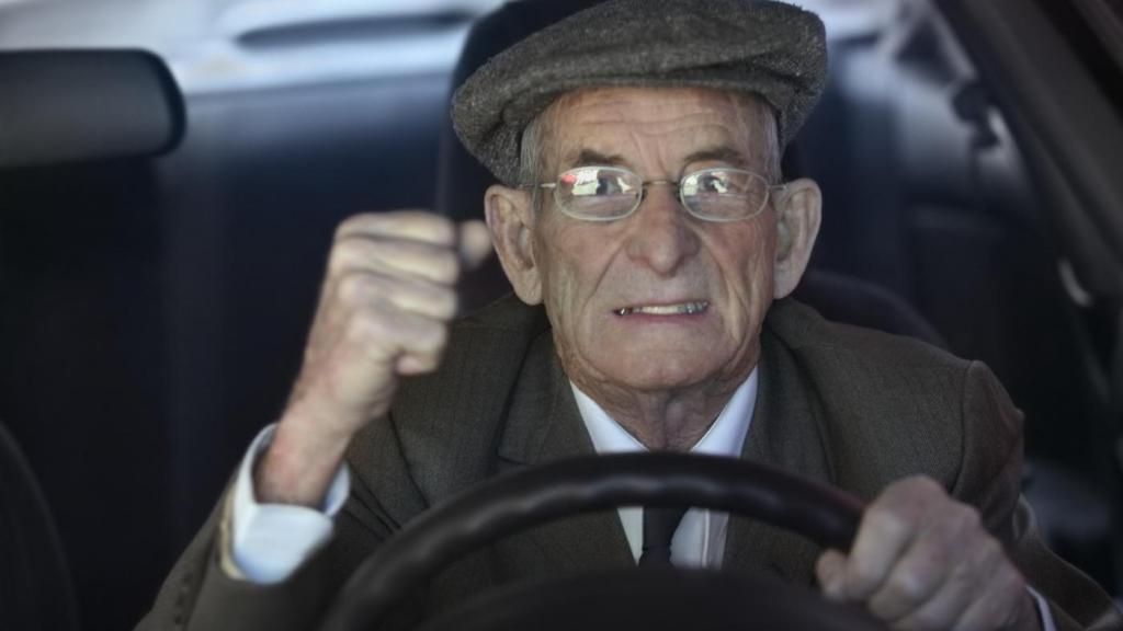 Пожилой мужчина за рулем