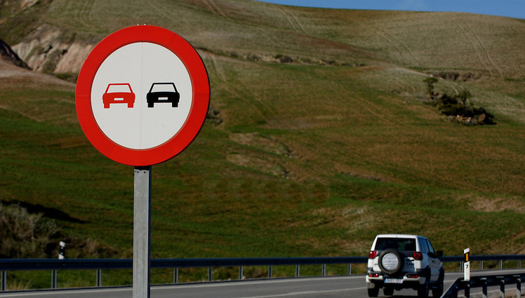 Знак обгон запрещен и машина на дороге