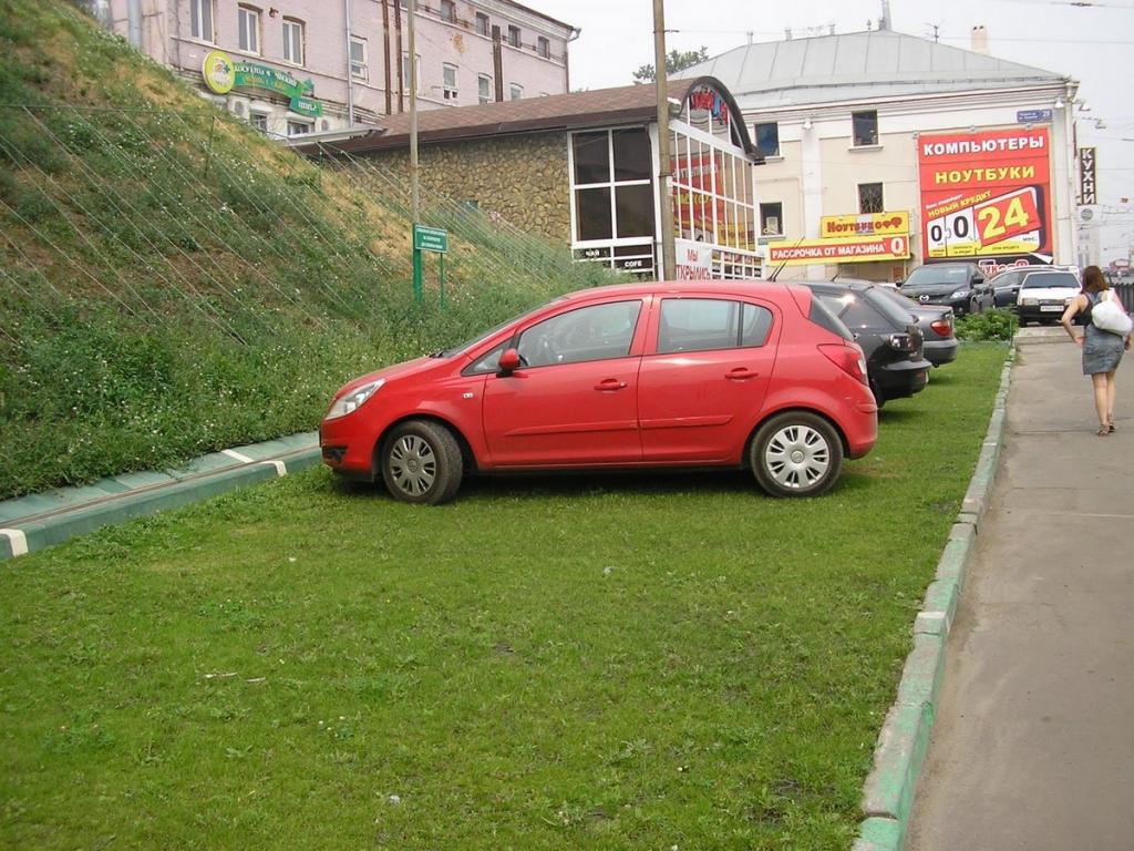 несколько автомобилей стоят на газоне